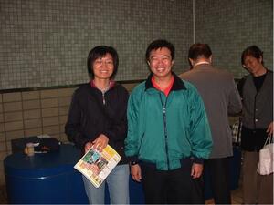 Two people in an indoor location smiling at the camera.