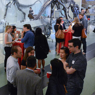 Junior Council Members enjoy beverages in the Museum's fourth floor dinosaur halls at an after-hours event.