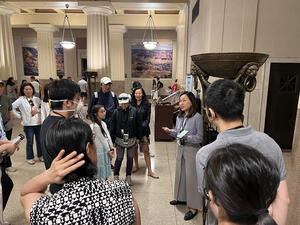 Museum volunteer Cindy speaks to a group of about a dozen people in the Theodore Roosevelt Memorial Hall while leading a highlights tour.