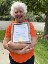 Ann McIntyre holds a framed certificate of 20 years of volunteer service.