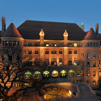 View of the exterior facade of the American Museum of Natural History at dusk.