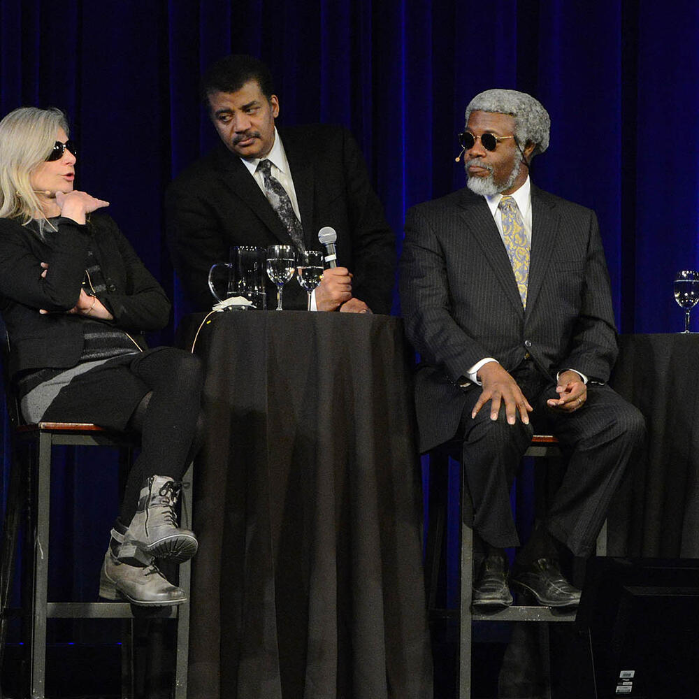Six panelists converse on a stage during the 2016 Asimov Debate.