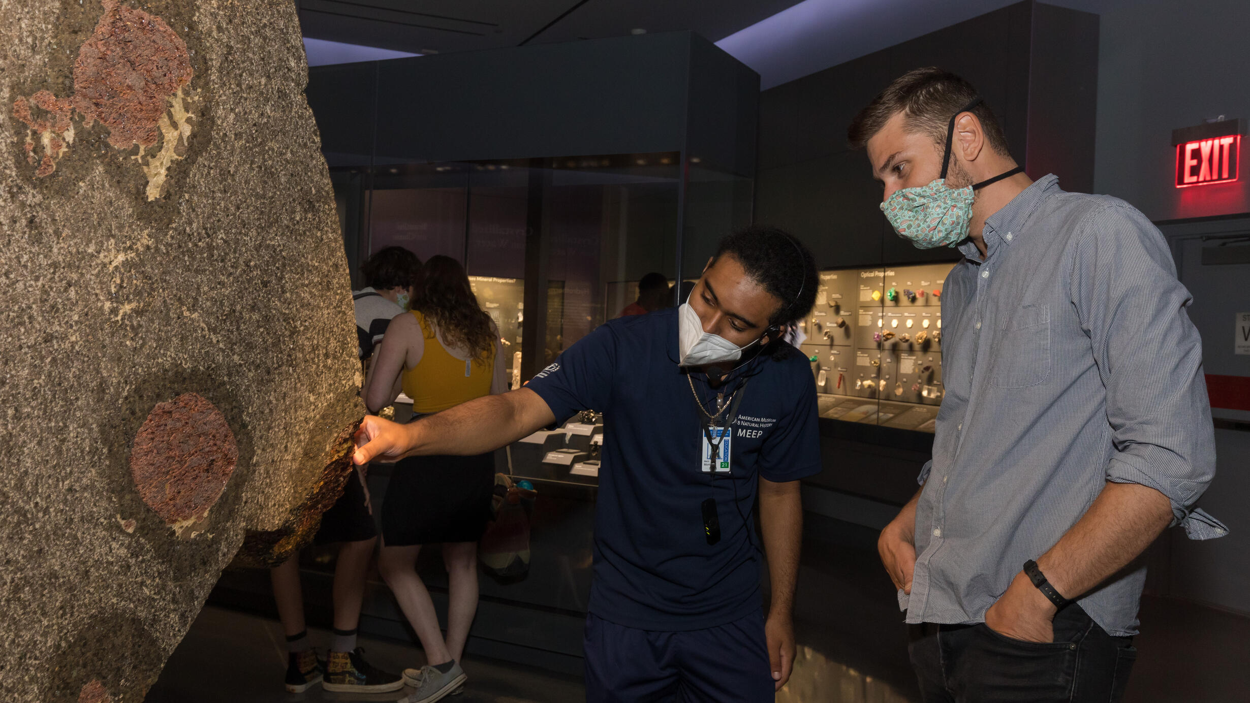 MEEP Intern with visitor looking at Garnet Slab in Gems and Minerals