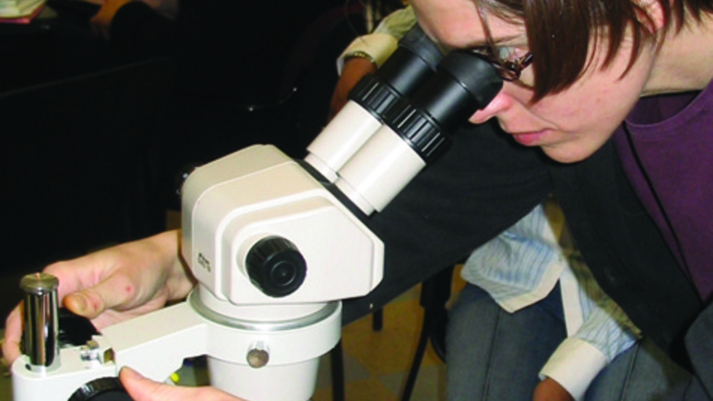 A person looking into a microscope.