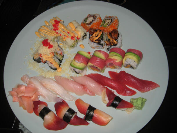 Multiple samples of colorful sushi on a large round plate.
