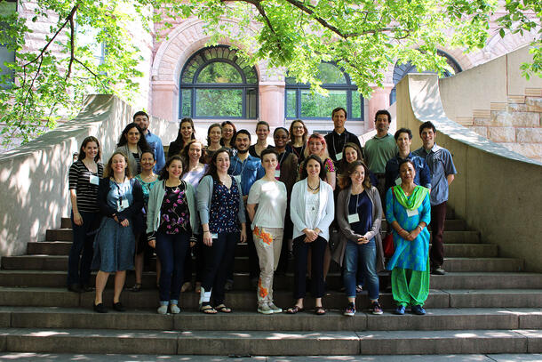 Three rows of 25 people posing on the steps of the Museum's 79th Street entrance. A tree above the group provides shade.