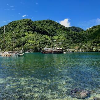 Boats in the water with mountains in the background in American Samoa