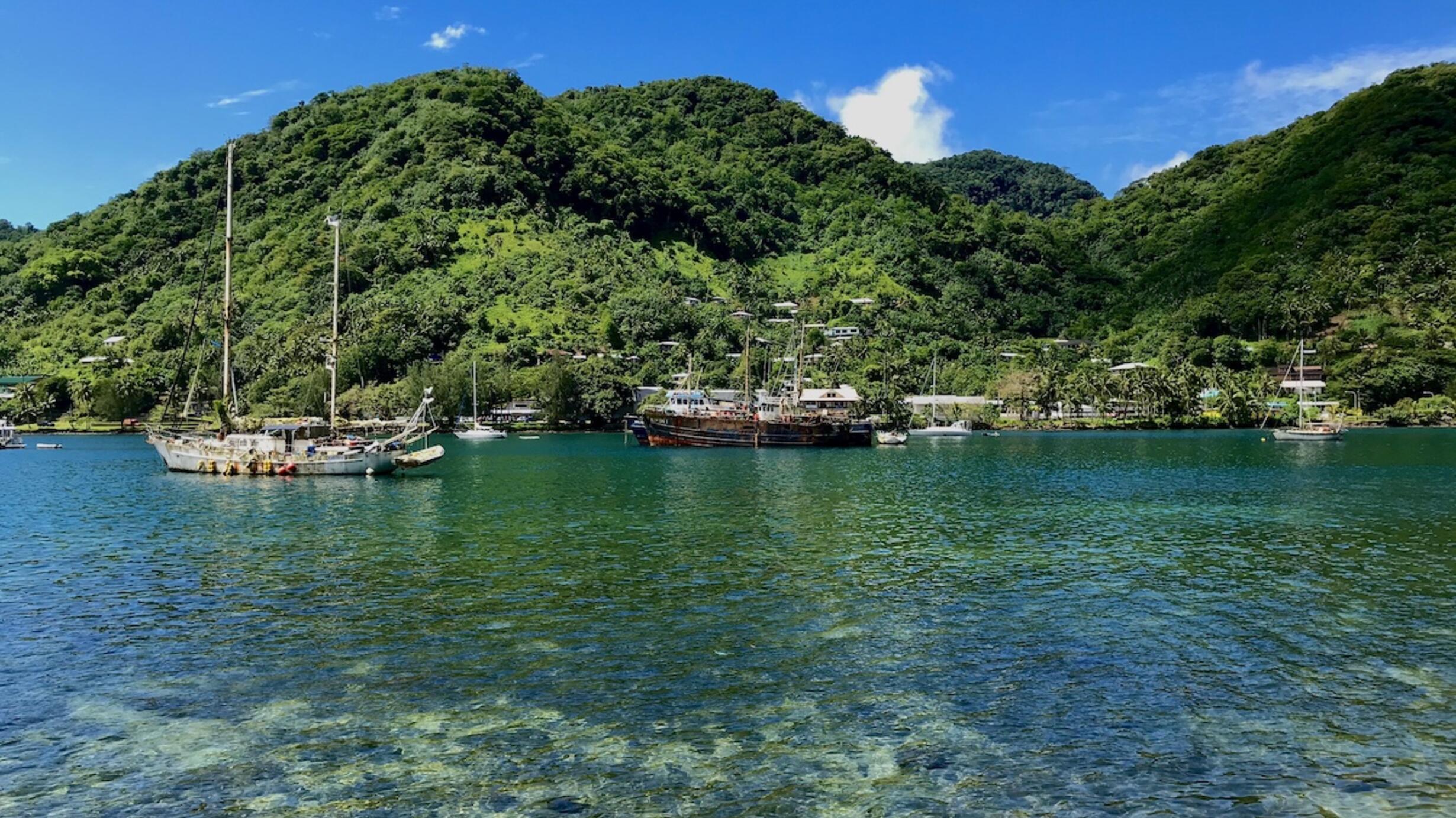 Boats in the water with mountains in the background in American Samoa