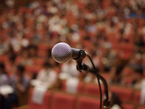 A microphone looms in front of a crowd.