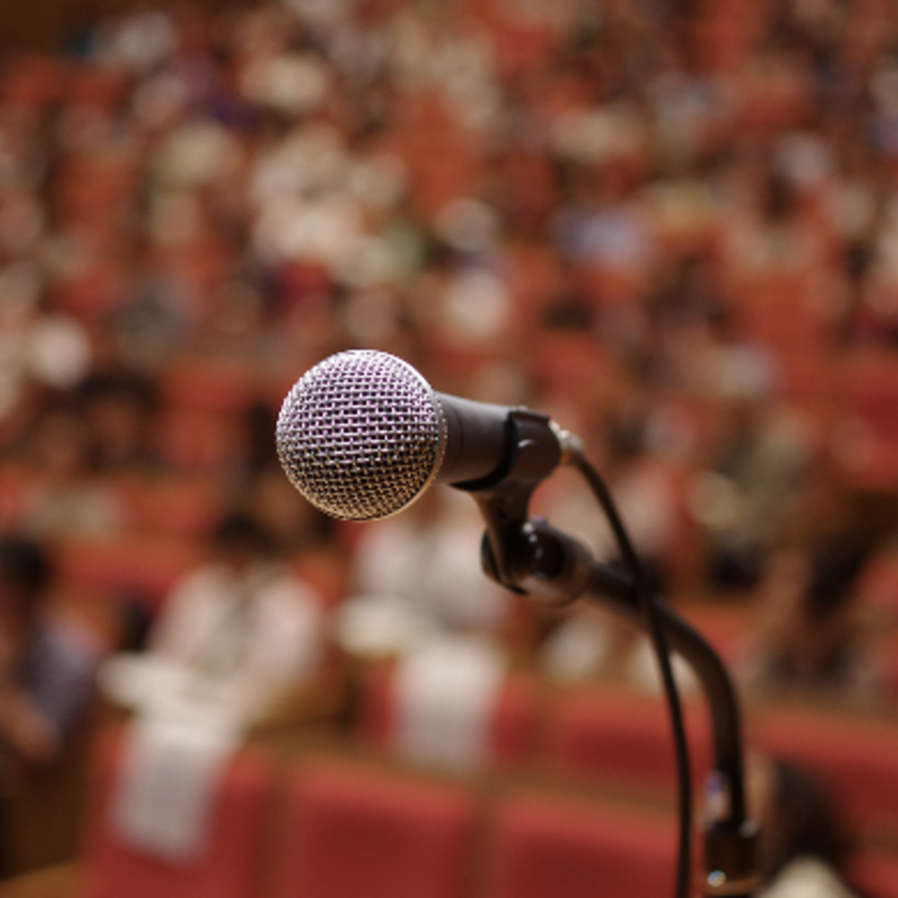 A microphone looms in front of a crowd.
