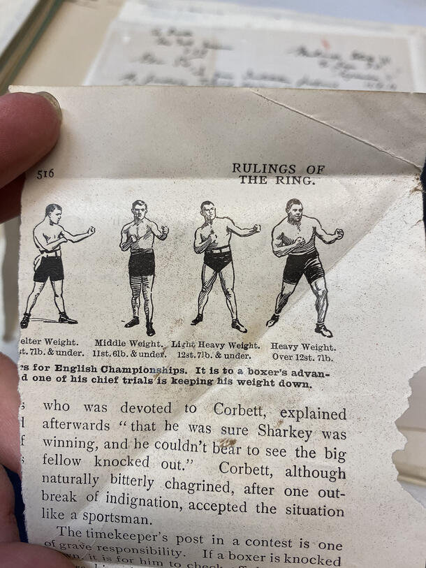 A torn out, folded magazine page reading "Rulings of the Ring" with an illustration of boxers captioned with their weight class.
