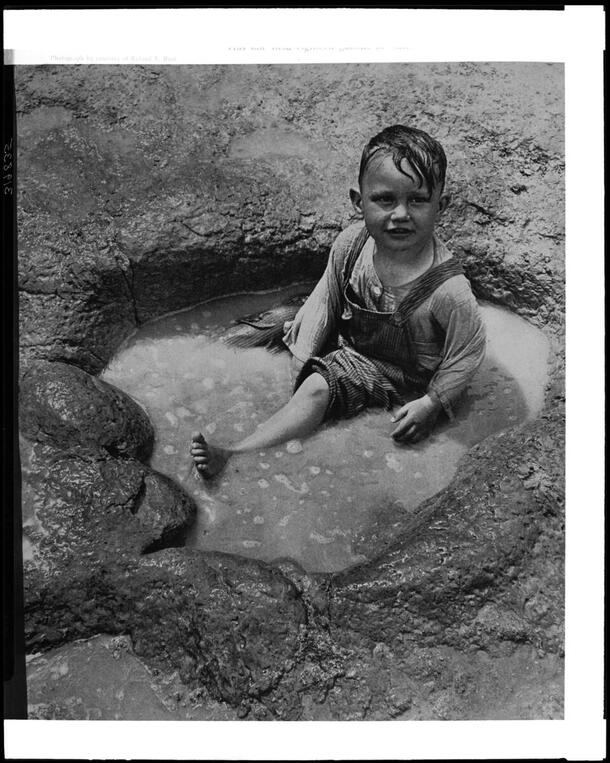 Child seated in dinosaur track which holds 18 gallons of water, October 1940, AMNH Library Image #319835
