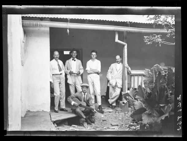 Frank M. Chapman standing outside of building with Museum expedition team, man with guitar is seated with them, Colombia, February, 1913