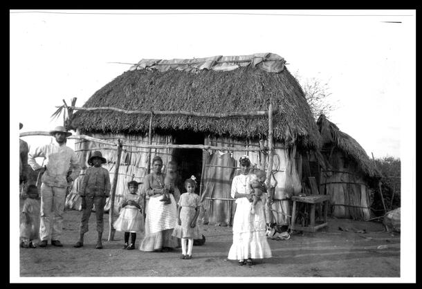 Group of people standing in front of their home, Trinidad, Cuba, 1892.