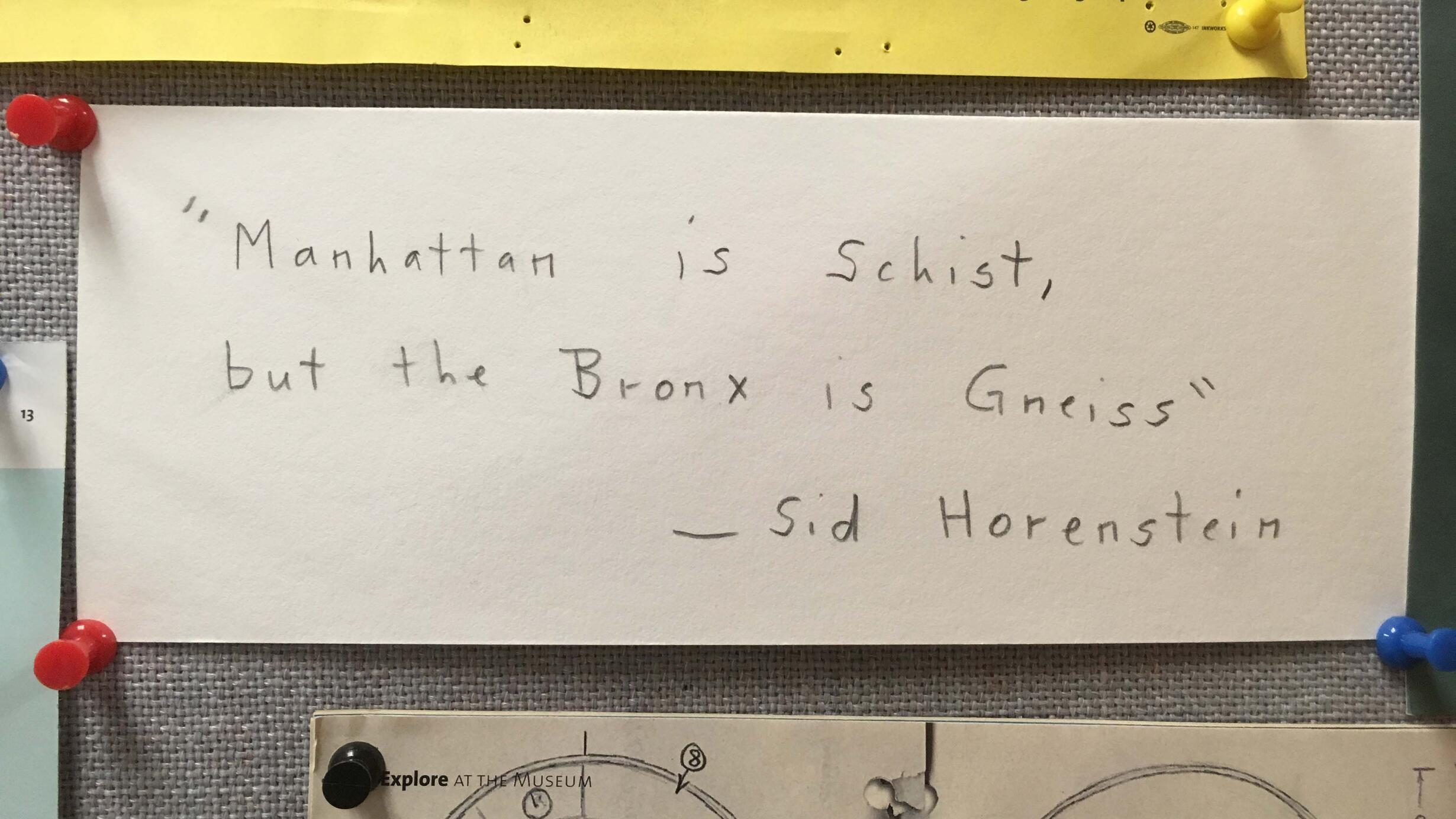 "Manhattan is schist, but the Bronx is gneiss. -Sid Horenstein" written on piece of paper pinned onto a board beside other pieces of pinned paper.