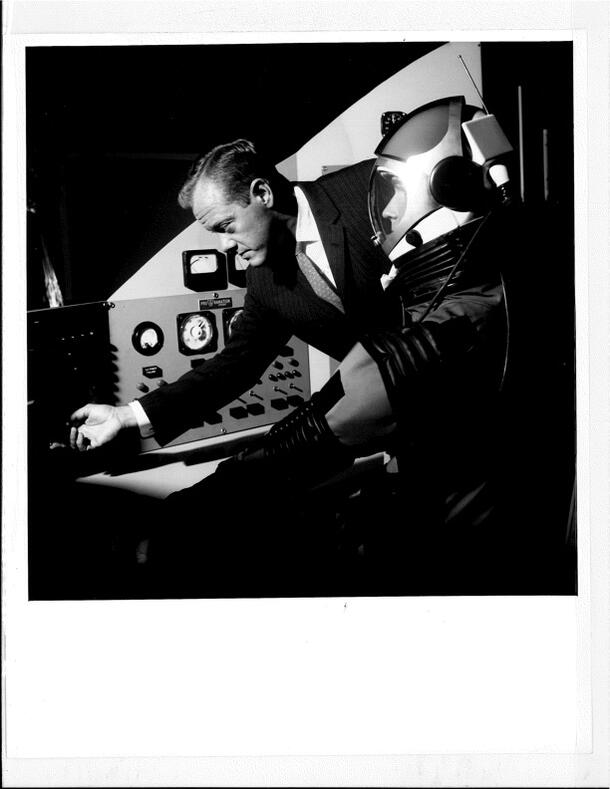 Press release photograph of Joseph M. Chamberlain at control panel of ARIES space laboratory, Man in Space exhibit, 1961