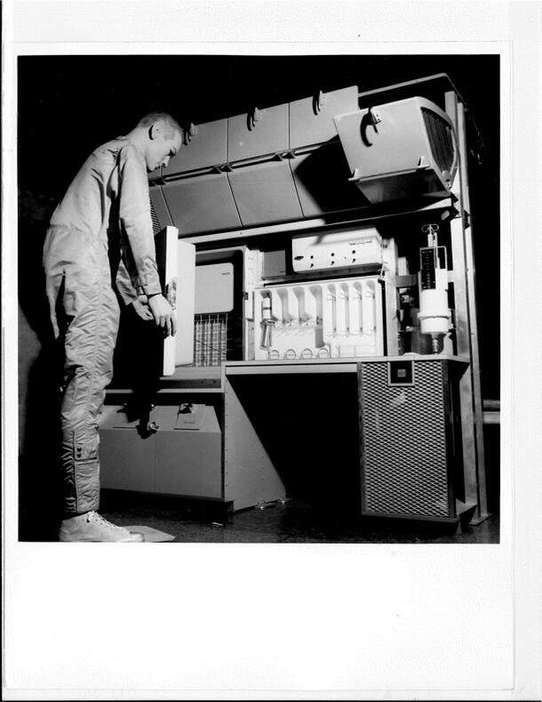 Press release photograph of mannequin in kitchen of ARIES space laboratory at Man in Space exhibit, 1961