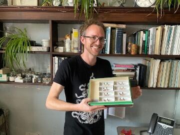 Smith is the Museum Specialist for the Coleoptera collection at AMNH. He holds a selection of specimens.