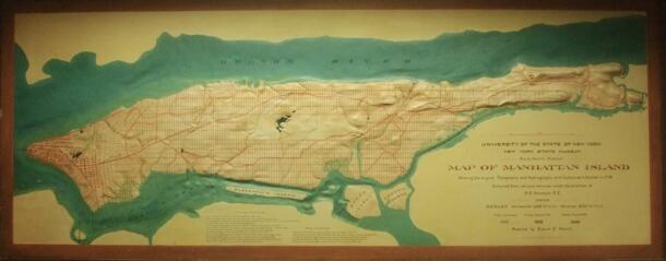 Photograph of Vermuele's nine foot wide plaster relief map of Manhattan hanging in the Library's archival processing area.