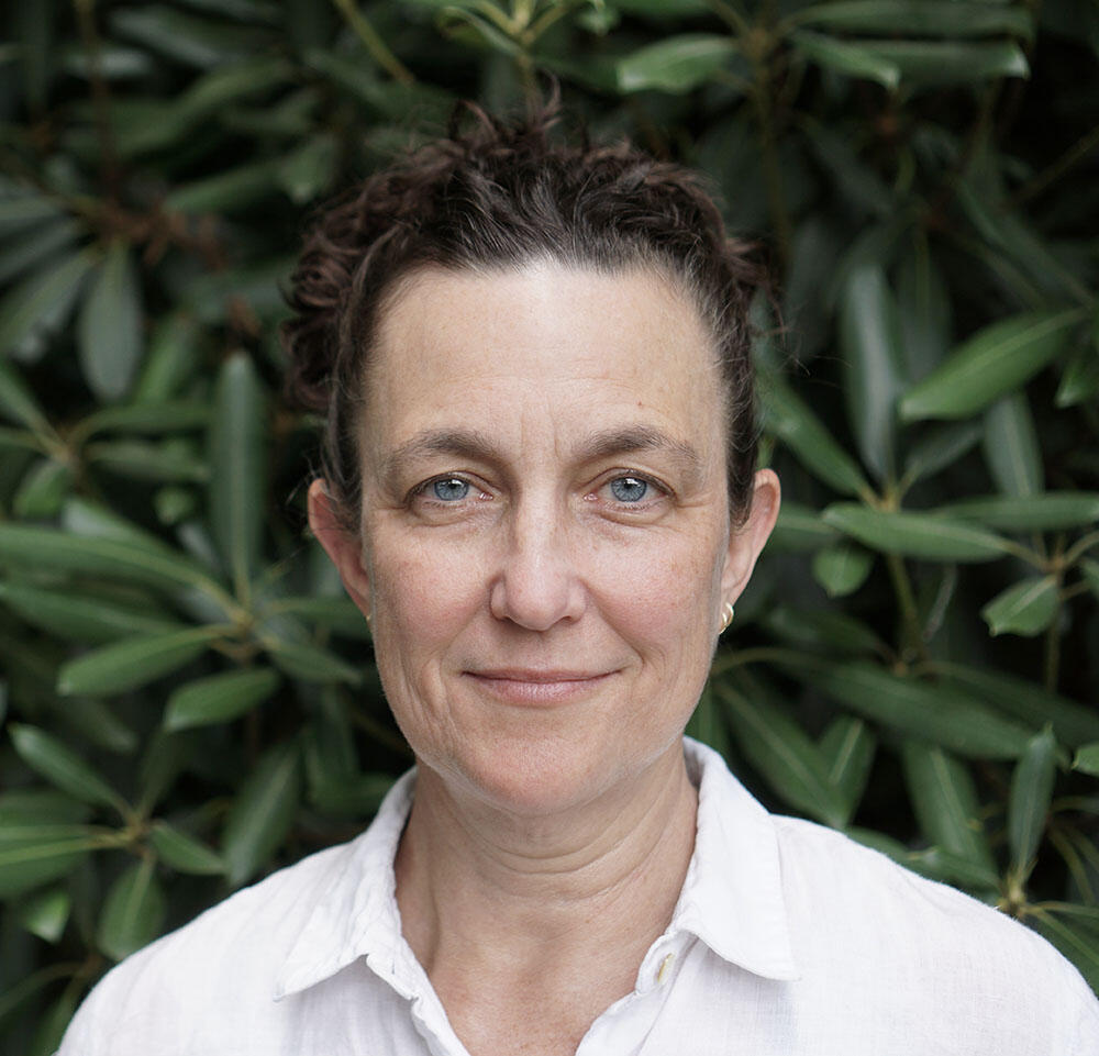 Headshot of Samantha Alderson standing in front of a rhododendron.