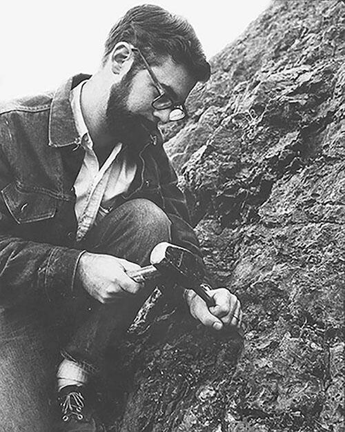 Niles Eldredge uses a hammer and chisel on a rock formation in the  Devonian Quarry.