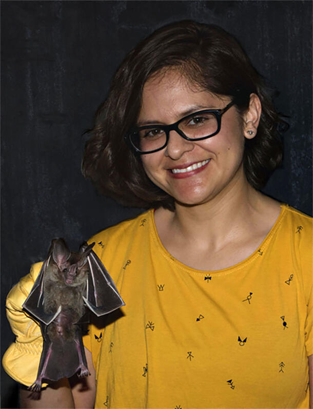 Dr. Ariadna Morales holds a bat in her gloved right hand.
