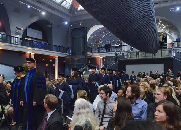 Beneath the Blue Whale in the Museum’s Hall of Ocean Life, guests are seated as a procession of graduates files past.