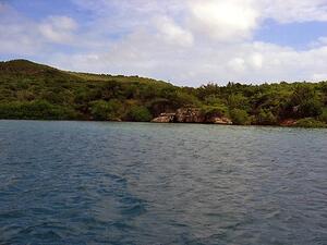 A wide shot of a lake with tree-covered hills in the background.