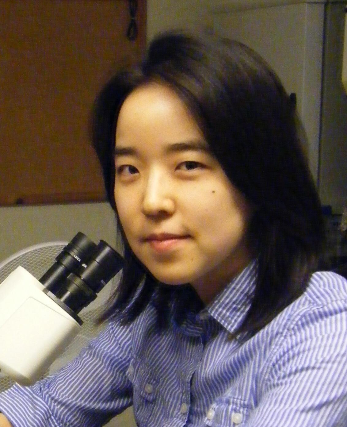 Picture of Museum scientist Dr. Eunsoo Kim with a microscope