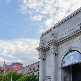 Early morning sunlight illuminates the main stairs and entrance to the American Museum of Natural History.