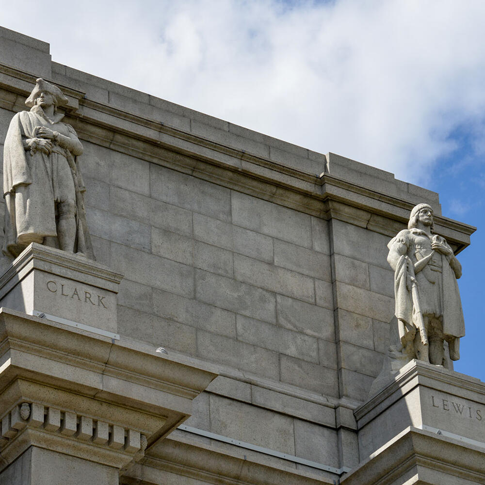 Labeled statues of William Clark and Meriwether Lewis on top of two Ionic columns on the Central Park West facade of the Museum.