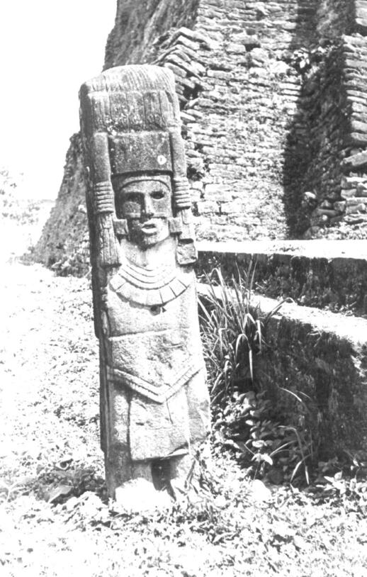 A tall carved stone column representing a human in elaborate costume and tall headdress, captioned "Anthropomorphic stela at Castillo de Teayo, Period VI."