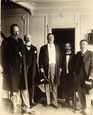 Theodore Roosevelt stands at the center, flanked by two people on each side.