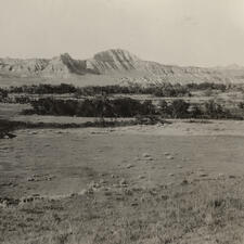 Flat landscape in the Dakotas with mountains in the background.
