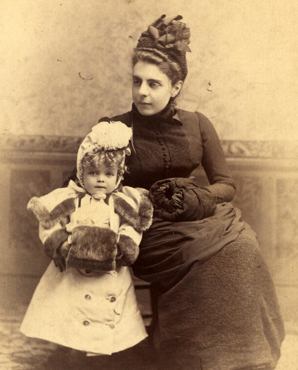 Anna Roosevelt seated beside baby Alice Roosevelt, wearing a pale coat and fur muff.