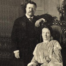 Theodore Roosevelt stands beside his wife Edith Carrow, who is seated.