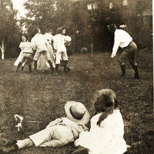 The Roosevelt children and other children playing outside—seven of them standing and playing a game, and two smaller children sitting in foreground.