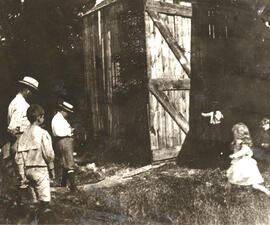 Six members of the Roosevelt family stand near the door of a barn.