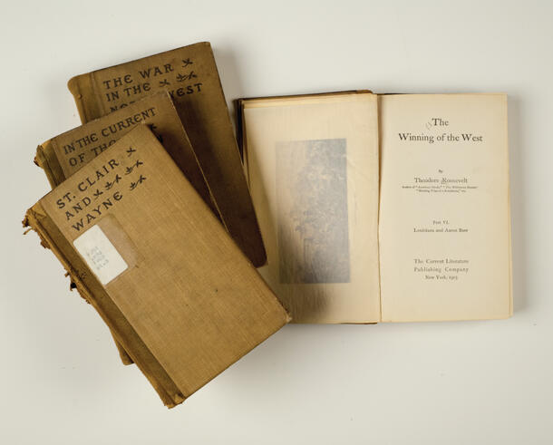 A copy of The Winning of the West open to its title page beside a staggered stack of three additional volumes of The Winning of the West.