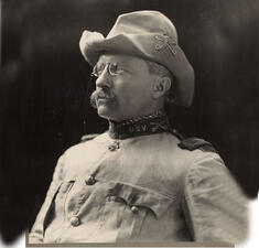 Theodore Roosevelt, wearing his Rough Rider cavalry jacket uniform and hat, in three quarter profile.
