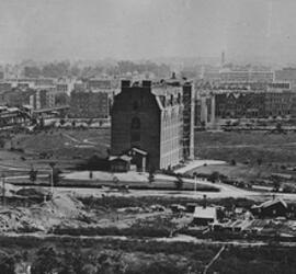 Historical photograph of the first building of the American Museum of Natural History, surrounded by flat, open ground.