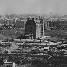 Historical photograph of the first building of the American Museum of Natural History, surrounded by flat, open ground.