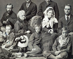 Theodore Roosevelt as a child, seated on the floor in the middle, surrounded by eight people.