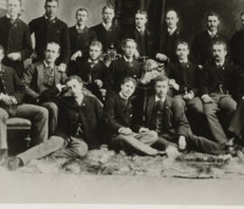 Group photo of sixteen members of the Harvard Porcellian Club in three rows, with Theodore Roosevelt in the second row, second from left.